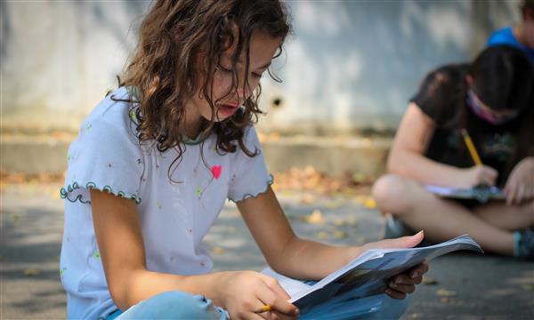 student writes on clipboard